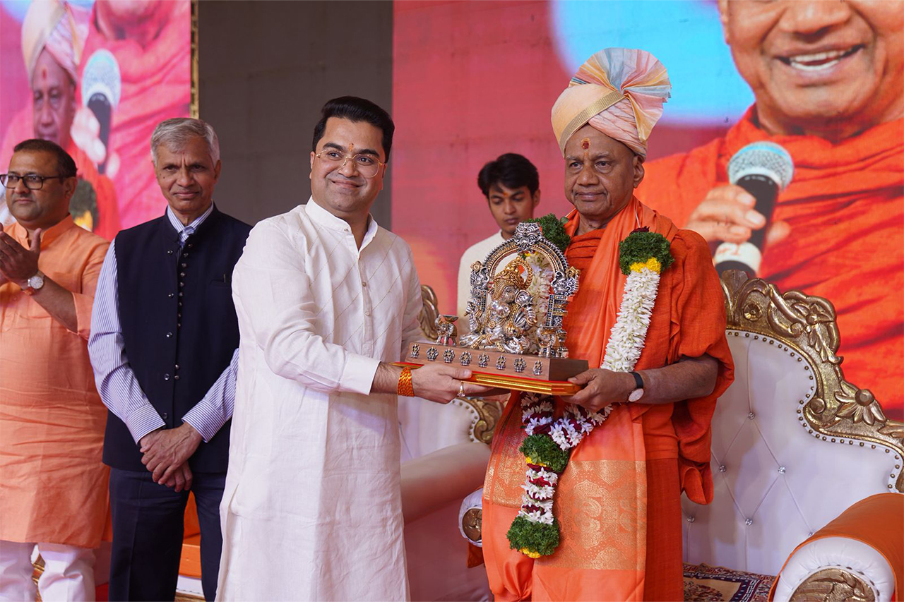 Abhay Bhutada handing Ganesh Idol to Swami Govind Dev Giri Maharaj at Gita Jayant Mahotsav in Alandi.